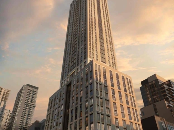 101 Spadina Condos A tall, modern skyscraper with a sleek design stands prominently against a sunset sky, part of the Toronto Real Estate landscape. The building's facade features large windows and geometric patterns. Nearby, other high-rise buildings are visible, and trees are in the foreground.
