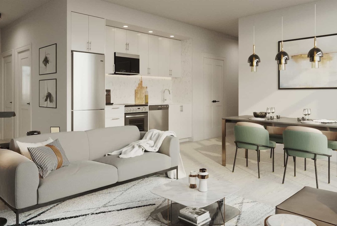 A modern open-plan living and dining area in new homes features a gray sofa with a throw blanket, a marble-top coffee table, and a dining table with green chairs. The kitchen boasts white cabinets and stainless steel appliances, while pendant lights elegantly hang above the dining area.