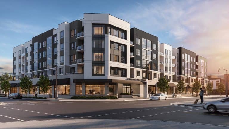Modern five-story apartment building with a mix of black, white, and gray exterior panels. Large windows and ground-floor retail spaces enhance the appeal of these new homes in GTA. The setting includes a few cars and trees, all under a clear sky at sunset.