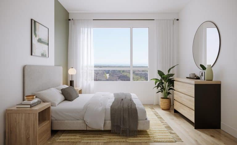 A bright, minimalist bedroom in one of the new condos boasts a large window showcasing a scenic view. It features a double bed with neutral bedding, a wooden nightstand, and a chest of drawers with a round mirror. Light wood flooring enhances the airy feel, complemented by a potted plant.