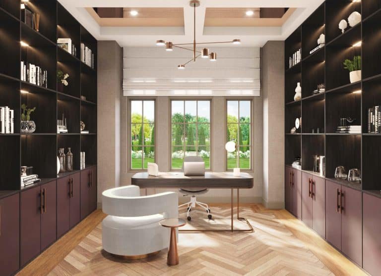 Modern home office with large windows revealing a lush green view. The room features built-in dark wood bookshelves, a contemporary desk with a sleek chair, and a stylish, curved white lounge chair with a small side table on a herringbone-patterned floor—true Clarehaven Estates elegance.
