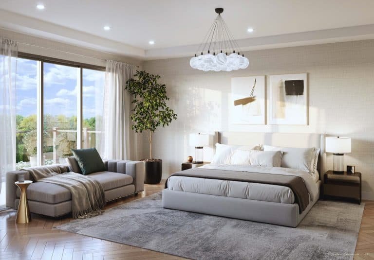 Modern bedroom at Clarehaven Estates with a large bed, light gray headboard, and neutral bedding. To the left is a comfortable sofa draped with a green blanket. A large window offers views of trees and lets in natural light. A chandelier hangs above, and there is a potted plant in the corner.
