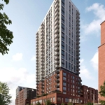 A modern high-rise building with a mix of red brick and glass facade, offering stunning new condos. The structure features numerous balconies and large windows. Street-level view shows people walking and trees lining the sidewalk under a clear blue sky.
