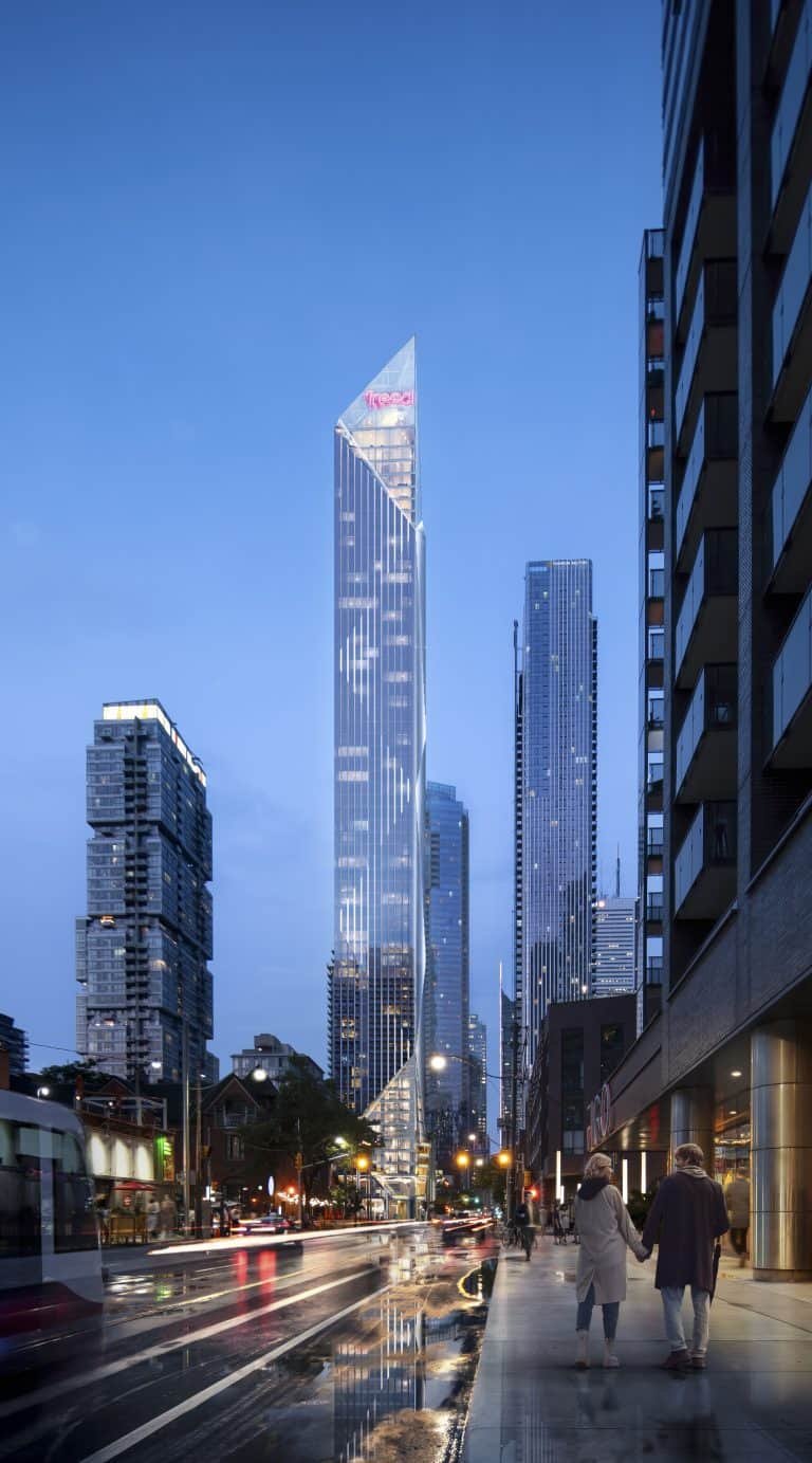A futuristic cityscape at dusk features the Freed Hotel, an angular skyscraper with a glowing red logo at the top. The streets are wet from rain, reflecting colorful city lights. People, including a couple holding hands, walk along the sidewalk near sleek residences.