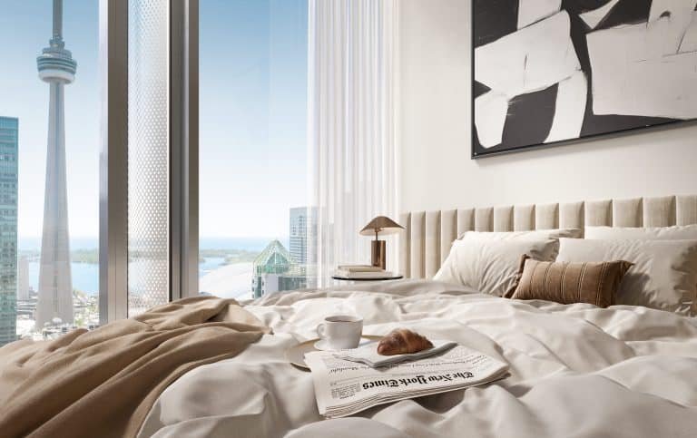 A cozy bedroom at Freed Hotel with a plush bed overlooking a stunning cityscape. On the bed are a newspaper, a coffee cup, and a croissant. A large window reveals a view of a tall tower and other buildings. The room is adorned with modern art and minimalistic decor, offering an inviting residence experience.