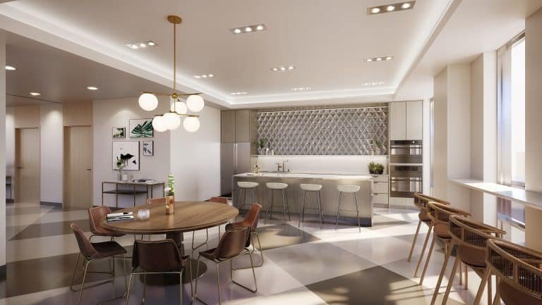 A modern kitchen and dining area in new GTA condos features a round wooden table, chairs, and bar stools around a large island. The room showcases geometric wall patterns, hanging lamps, artwork, and large windows ushering in natural light.