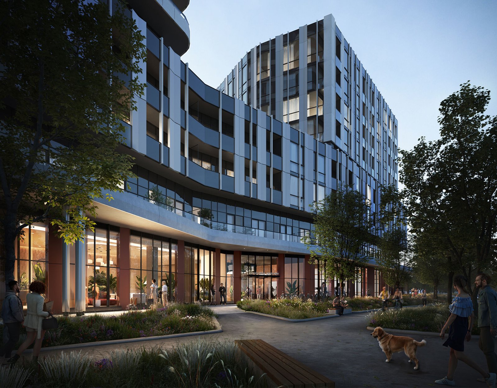 The Clove is a modern multi-story building with a glass and metal exterior, featuring ground-level retail spaces lit warmly inside. People are walking on the pathway outside, with trees and plants lining the route. A person is walking a dog in the foreground.