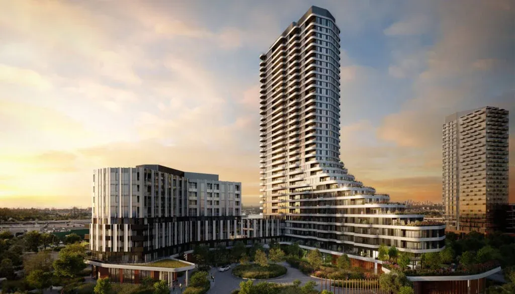 The Clove, a modern high-rise residential building with a unique, flowing design, stands majestically against a sunset sky. Surrounding the main tower are smaller buildings and lush greenery. The architecture features a mix of glass and concrete, emphasizing contemporary design.