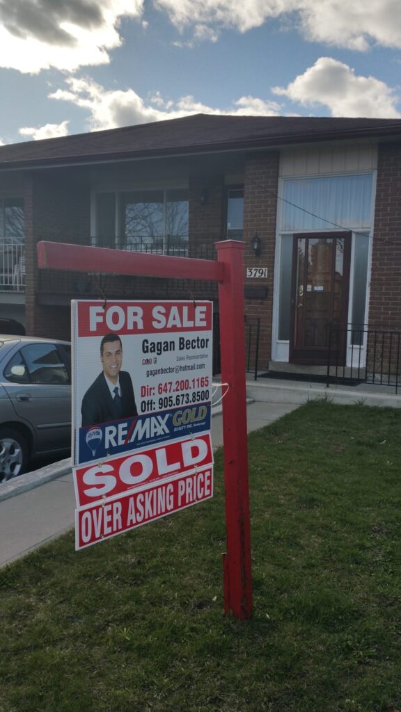 A for sale sign in front of a house.