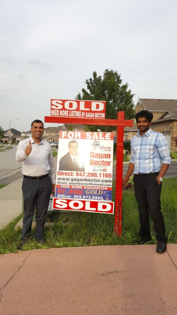 Two men standing next to a sign.