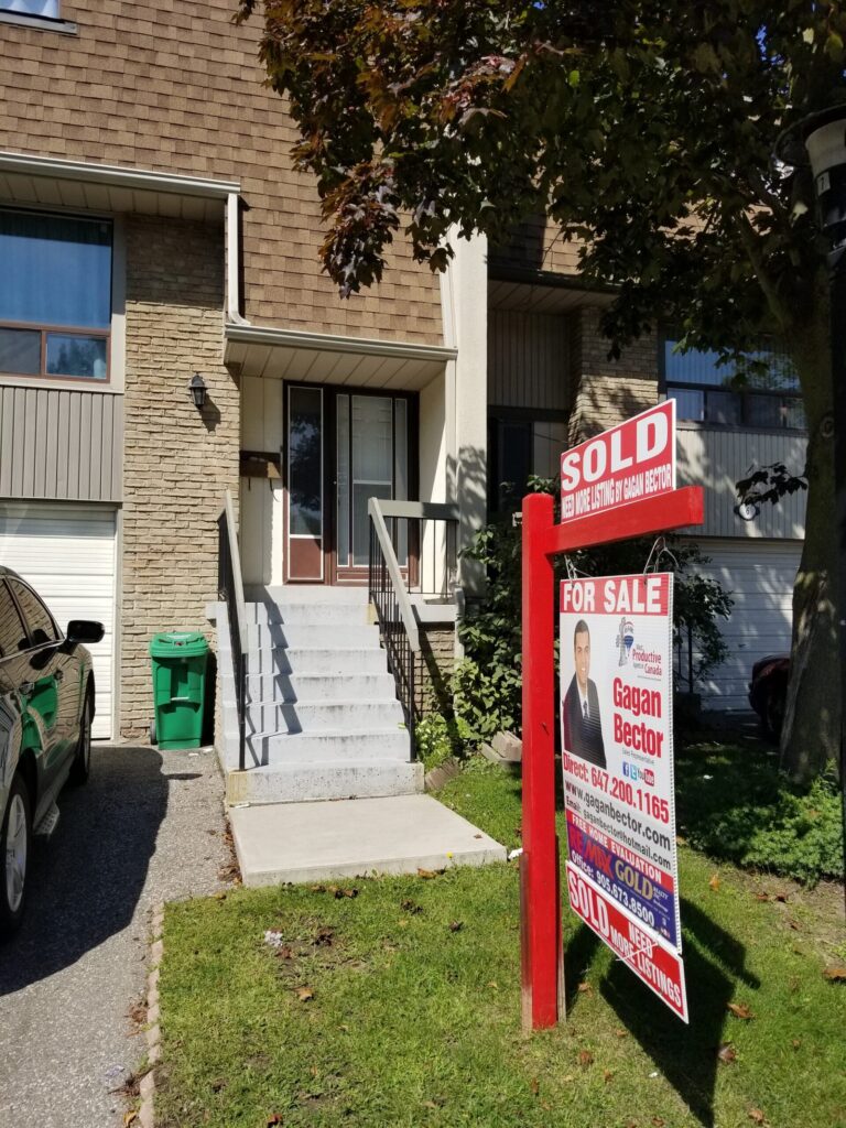A house with a sold sign in front of it.