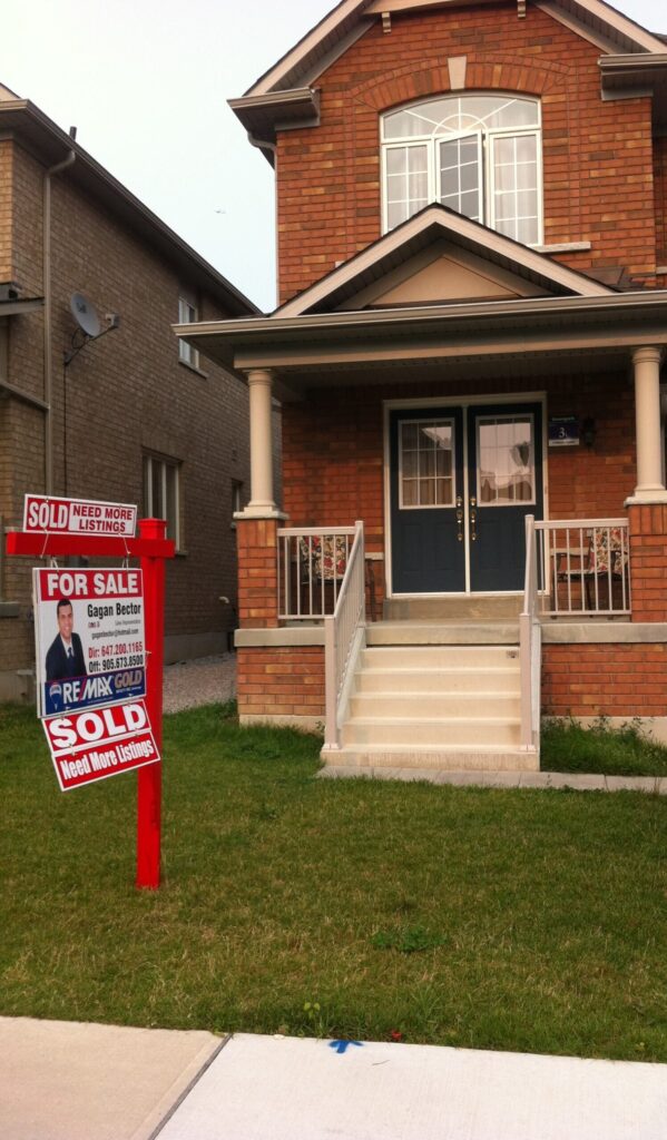 A house with a for sale sign in front of it.