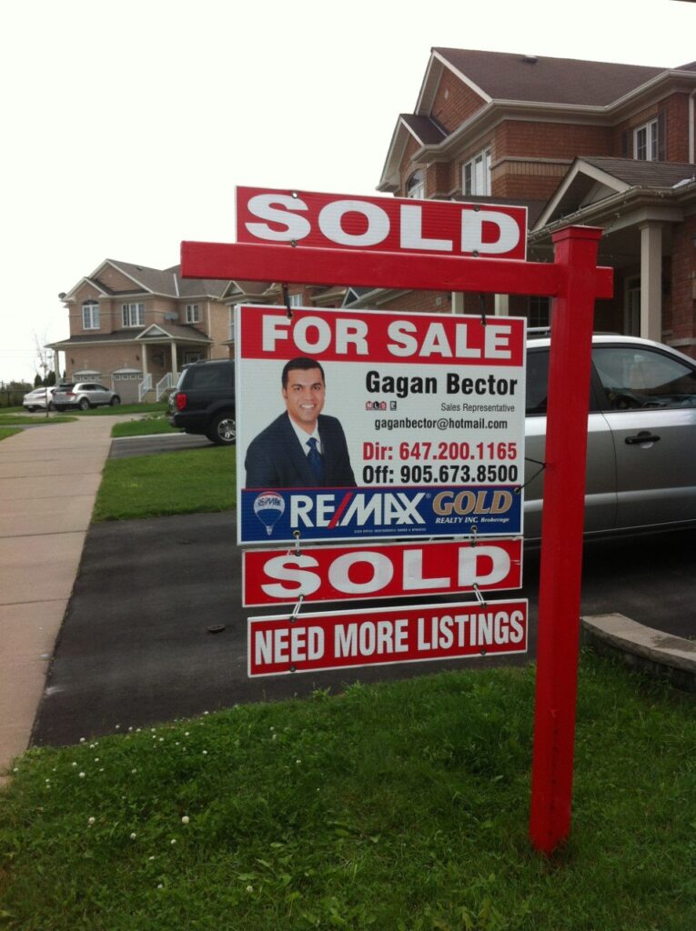 A for sale sign in front of a house.