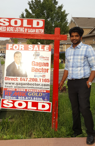 Two men standing in front of a for sale sign.
